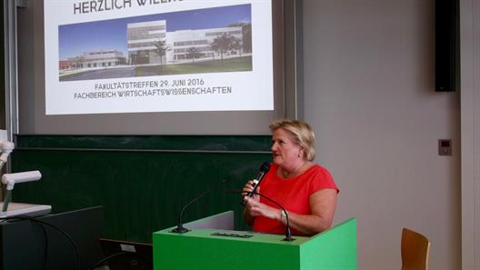 Man sieht Prof. Dr. Brigitte Grass, Präsidentin der Hochschule Düsseldorf. Sie steht an einem Rednerpult und spricht in ein Mikrophon.