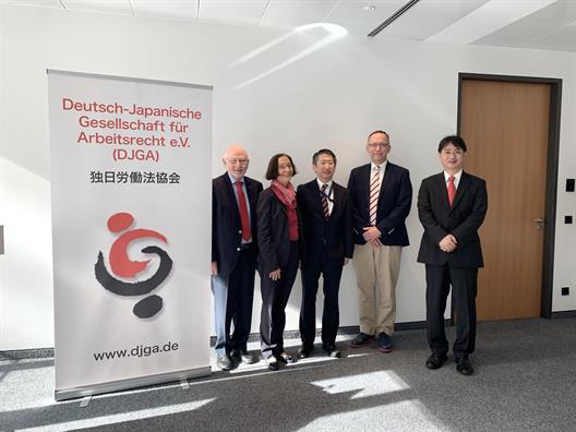 Tagung der Deutsch-Japanischen Gesellschaft für Arbeitsrecht e. V. in Kooperation mit der Bundesvereinigung der Deutschen Arbeitgeberverbände e. V. Folgende Personen stehen neben einem Banner der Deutsch-Japanischen. Gesellschaft für Arbeitsrecht: Prof. Düwell RiBAG a. D.; Frau Hornung-Draus, Geschäftsführerin BDA; Gesandter Araki, Botschaft von Japan; Karsten Haase, Lehrbeauftragter HSD; Prof. Dr. Takahashi, Rissho-Universität Tokyo