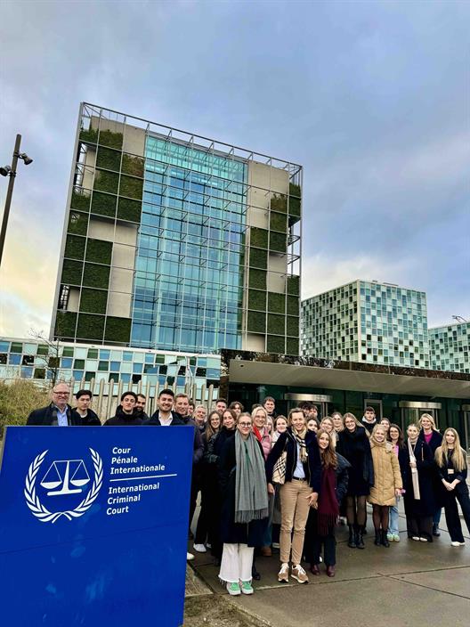 Die Exkursionsteilnehmer stehen in einer Gruppe vor dem International Criminal Court (Internationaler Strafgerichtshof).